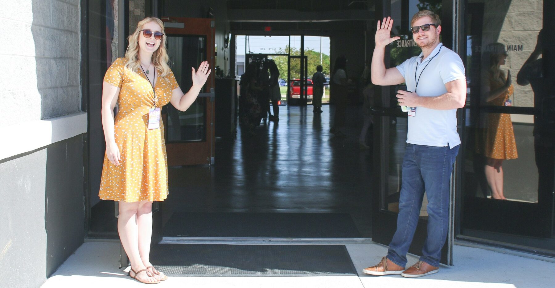 two man and woman standing on doorway