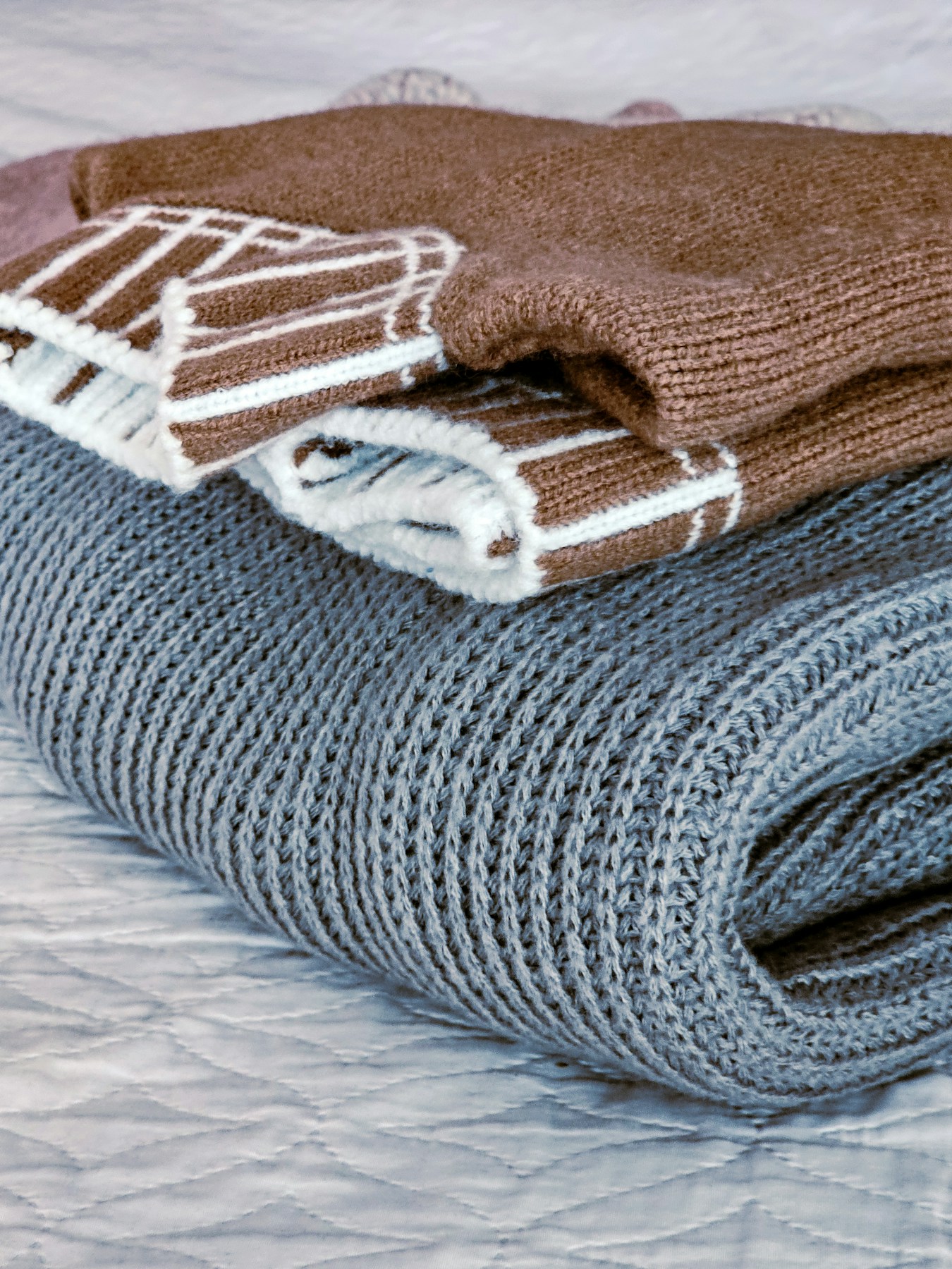 A pile of blankets sitting on top of a bed