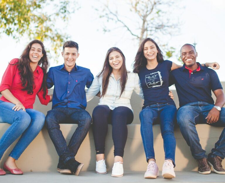 group of people sitting on bench near trees duting daytime